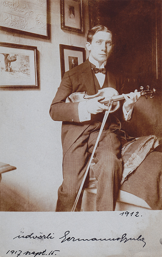 Az ifjú Germanus Gyula hegedűvel, Budapest, 1912. (Germanus válla fölött félig takarásban látható Vámbéry Ármin bekeretezett, Germanusnak dedikált fényképe, amely a hagyatékkal együtt bekerült a Magyar Földrajzi Múzeumba). Forrás: Magyar Földrajzi Múzeum